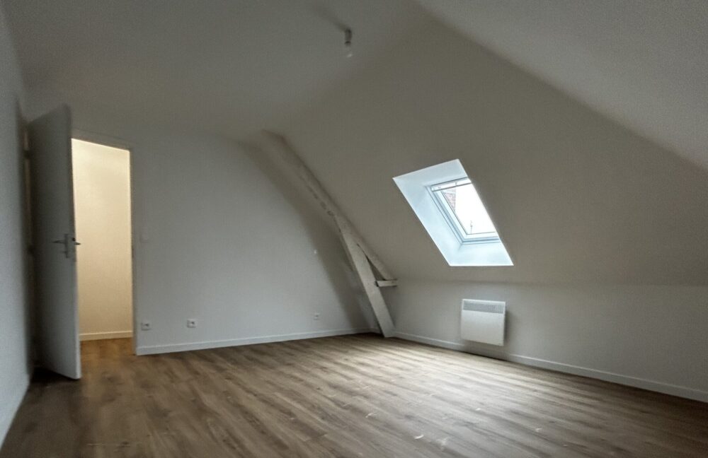 Combles aménagés en chambre lumineuse avec fenêtre de toit et parquet stratifié, réalisation De Sousa Home, Nord