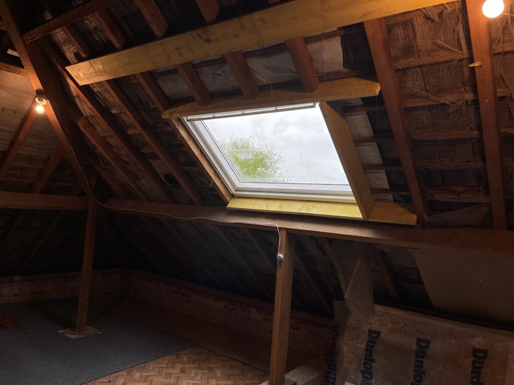Fenêtre de toit Velux installée dans des combles bruts, vue intérieure, Blaringhem, Hauts-de-France