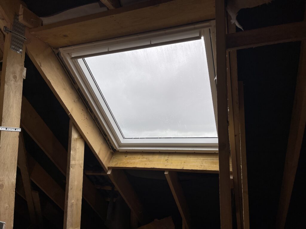 Installation fenêtre de toit Velux SK06 dans charpente bois, vue intérieure avant finitions, Sailly-sur-la-Lys, Hauts-de-France