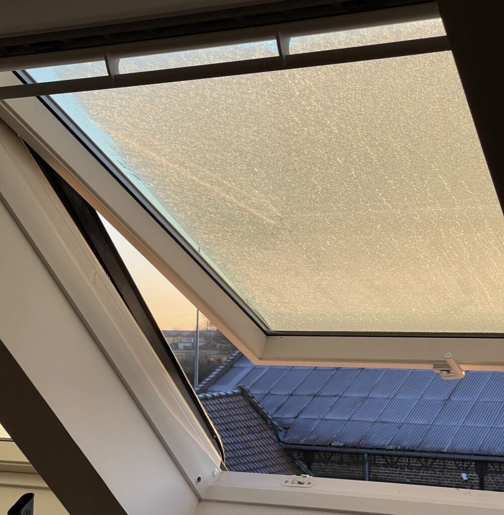 Fenêtre de toit Velux ouverte avec store intégré, vue sur toiture, pose De Sousa Home, Hauts-de-France